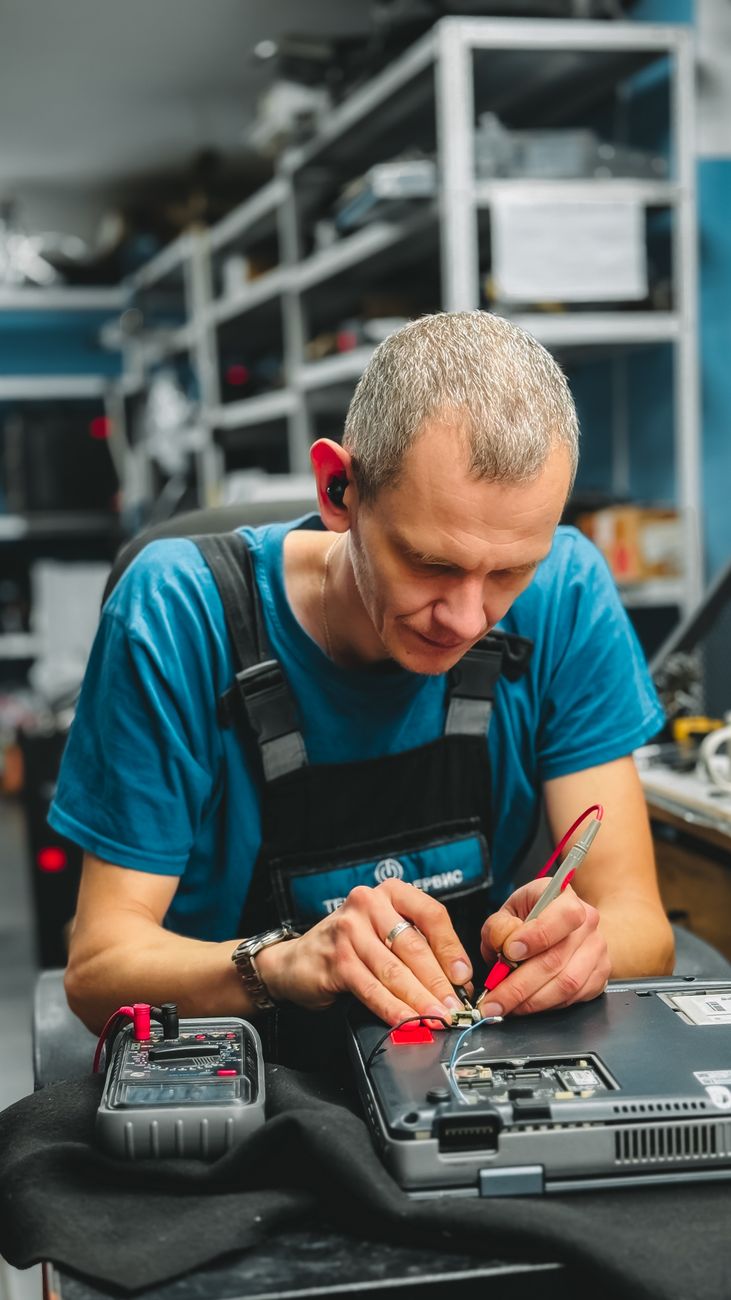 Tekniker med bærbar computer ved en maskine